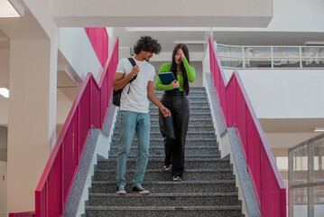 Wall Mural - A happy male and female college students are walking in the university hallway.