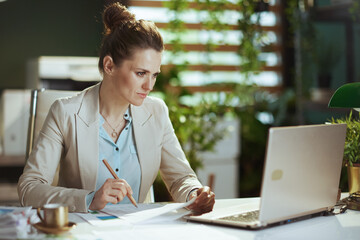 bookkeeper woman in light business suit in green office