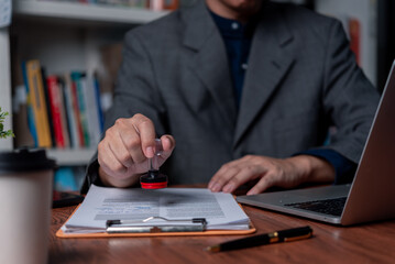 Wall Mural - Man stamping approval of work finance banking or investment marketing documents on desk.