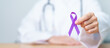 © Jo Panuwat D - Doctor holding purple Ribbon for Violence, Pancreatic, Esophageal, Testicular cancer, Alzheimer, epilepsy, lupus, Sarcoidosis and Fibromyalgia. Awareness month and World cancer day concept