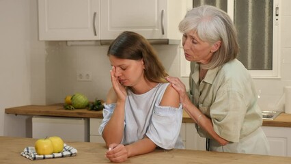 Wall Mural - Elderly mother asks for forgiveness from her adult daughter and calms her down after a domestic quarrel in the kitchen. High quality 4k footage