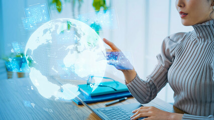 Wall Mural - young woman touching holographic planet earth in office.