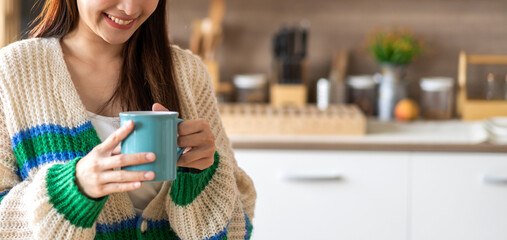 Portrait of smiling happy cheerful beauty pretty asian woman relaxing drinking and looking at cup of hot coffee or tea.Girl felling enjoy having breakfast in holiday morning vacation at home