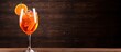 © vxnaghiyev - Traditional Italian cocktail Aperol Spritz on wooden background celebrating 100 years of aperitif