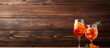© vxnaghiyev - Traditional Italian cocktail Aperol Spritz on wooden background celebrating 100 years of aperitif