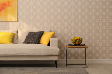 Sticker - Comfortable beige sofa and side table near wall. Minimalist living room interior