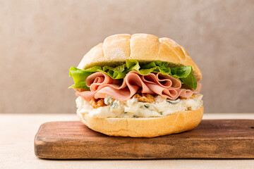 Poster - Italian sandwich or panino with mortadella, gorgonzola cheese, walnuts, Romaine lettuce, tartaruga bread. Sliced mortadella from Bologna - a large italian sausage or luncheon with meat.