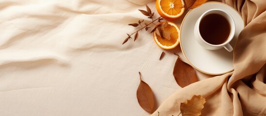 Poster - Flat lay composition in autumn or winter with a coffee cup dry leaves and dried orange on a linen fabric background Copy space available representing autumn or fall