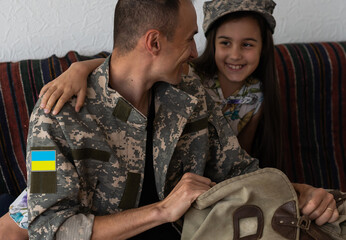 Wall Mural - Soldier in Ukrainian military uniform hugging his daughter. Family reunion