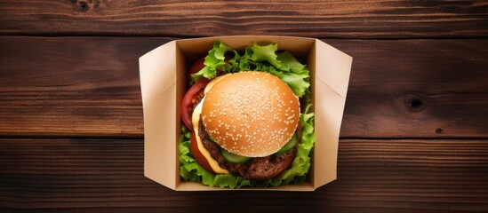 Leinwandbilder - Top down view of a rustic wooden table with a paper box containing a fresh hamburger