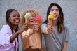 Three multiracial happy friends with ice creams in summer at street.