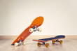 Two skateboards yellow and red on a wooden floor background