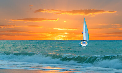 Wall Mural - Lonely yacht sailing in the Mediterranean sea at amazing sunset - Sailing luxury yacht with white sails in the Sea.