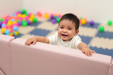 Wall Mural - happy infant baby standing in fence of playpen