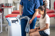 © puhimec - Doctor using machine to treat the knee joints of a patient.