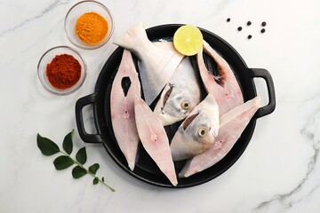 Wall Mural - Fresh whole Silver Pomfret fish or butter fish or Poplet cut into slices. cleaned and ready for frying along with spices. ingredients and recipe background with copy space