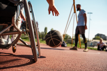 A physically challenged man in a wheelchair fearlessly engages in a spirited game of basketball with his supportive friends, breaking barriers and proving that passion and teamwork know no bounds.