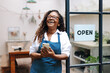 © (JLco) Julia Amaral - Successful small business owner holding a smartphone as she launches her shop