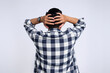 Back view of stressed young Asian man in casual shirt grabbing his head and expressing problem isolated on white background