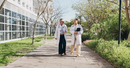 Wall Mural - Doctors, tablet and walking for healthcare collaboration, medical conversation and surgery planning outside. Telehealth, professional workers and people in communication and patient analysis on web