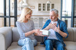 © brizmaker - Senior wondered man feeling thankful for getting present from woman