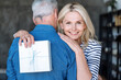 Portrait of mature couple, woman holding gift box behind male back