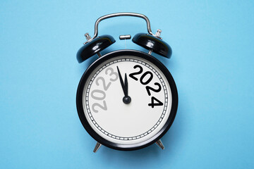 Wall Mural - 2023 and 2024 on black alarm clock with copy space , merry christmas and happy new year concept.