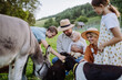 Portrait of farmer family petting animals on their farm.