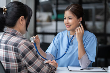 Asian female doctor using a stethoscope to examine a patient, ask for information, give advice, comfort, plan a course of treatment and preventive care. concept of health check