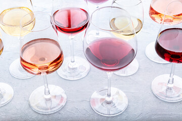 Wall Mural - Wine glasses at a tasting. Rose, red, and white wine, drinks on a table at a winery. An assortment of wines of various colors