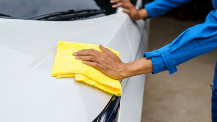 Man cleaning the car with a clean cloth, washing the car, wiping the car, polishing the car, wiping dust