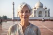 © Markus Schröder - Close-up portrait photography of a content mature woman wearing a versatile denim shirt in front of the taj mahal in agra india. With generative AI technology