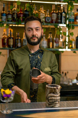 A professional bartender juggles a shaker The process of making cocktails in a club at a bar