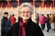 © Markus Schröder - Medium shot portrait photography of a joyful mature woman wearing an ornate brooch at the palace museum (forbidden city) in beijing china. With generative AI technology