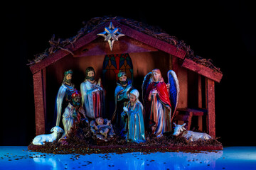 Virgin Mary, Joseph and baby Jesus. Religious scene. Christmas Manger scene with figures of Jesus, Mary, Joseph, sheep and magi. Statuettes of the Nativity.