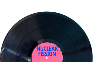 Wall Mural - Nuclear fission symbol. Concept words Nuclear fission on beautiful black vinyl disk. Beautiful white table white background. Business science nuclear fission concept. Copy space.