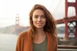 Close-up portrait photography of a satisfied girl in her 20s wearing a chic cardigan at the golden gate bridge in san francisco usa. With generative AI technology