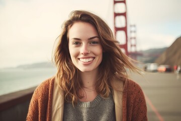 Wall Mural - Close-up portrait photography of a satisfied girl in her 20s wearing a chic cardigan at the golden gate bridge in san francisco usa. With generative AI technology