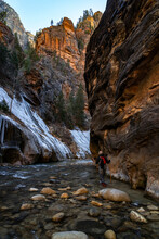 Person Hiking Through The Icy And Cold Narrows In Zion National Park In Utah