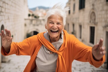 Poster - Medium shot portrait photography of a joyful old woman wearing a comfortable yoga top at the dubrovnik old town in dubrovnik croatia. With generative AI technology