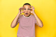 © Asier - Shaved head woman in red striped tee, yellow backdrop keeping eyes opened to find a success opportunity.