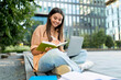 © Prostock-studio - Cheerful young woman student getting ready for class, using laptop