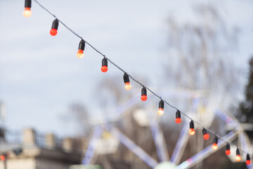 Canvas Print - Christmas market in a European city. Wooden houses are illuminated by garlands and Christmas decorations in the evening. Christmas decorations at the fair.