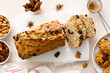 Fruitcake with cranberry, almond and pecan nuts sliced on a wooden board