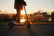 © baranq - Picture of a man riding electric scooter in park during sunset in autumn or winter