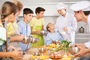 Wall Mural - Chef apprentices learn how to properly beat eggs with a whisk in a cooking class