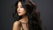 Beautiful young asian woman with long curly hairstyle on dark background.