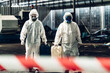 © kanpisut - Scientist wear Chemical protection suit check danger chemical, working at dangerous zone in Red and White Lines of barrier tape. Red and white Hazardous restricted area factory safety worker industry