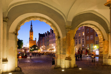 Wall Mural - Illuminated streets of Gdansk with spire of Main Town Hall in twilight, Poland.