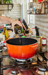 Poster - Chef pouring olive oil into pan on gas stove